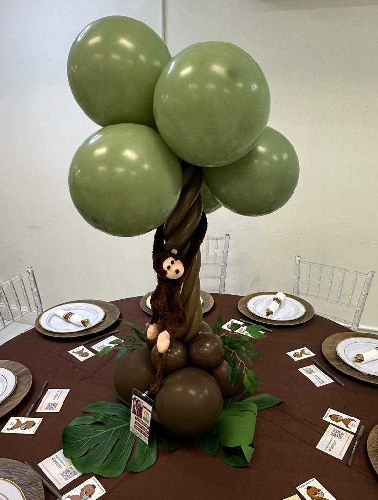 Monkey themed balloon centerpiece displayed on a guest table at Prince Elijah's baby shower.
