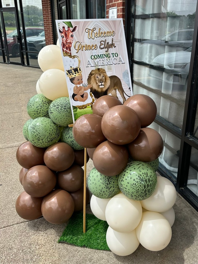 Welcome Prince Elijah Coming to America themed baby shower sign with safari balloons outside the venue in Dallas, Texas.