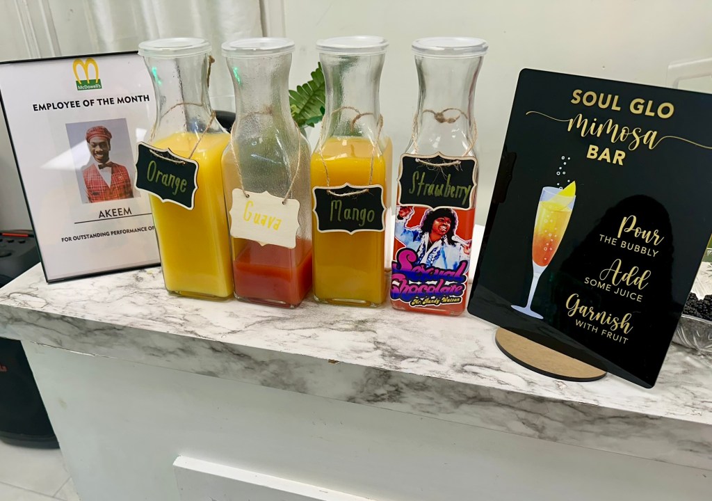 Soul Glo themed mimosa bar with fruit juices at Prince Elijah's Coming to America themed baby shower.
